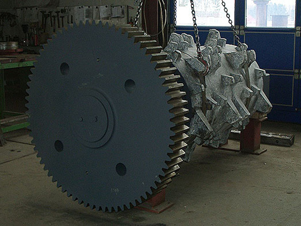 Großes Zahnrad und Bauteil für Maschinenreparatur | BSS GmbH Großes Zahnrad mit Maschinenbauteil in einer Werkstatt
